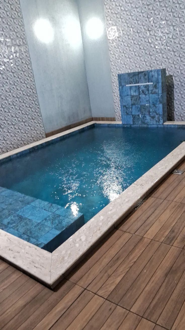 Piscina com deck de madeira e cascata